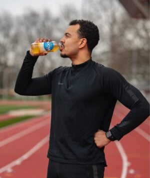 Ein Sportler trinkt nach dem Sport ein Focuswater Active Vitaminwasser