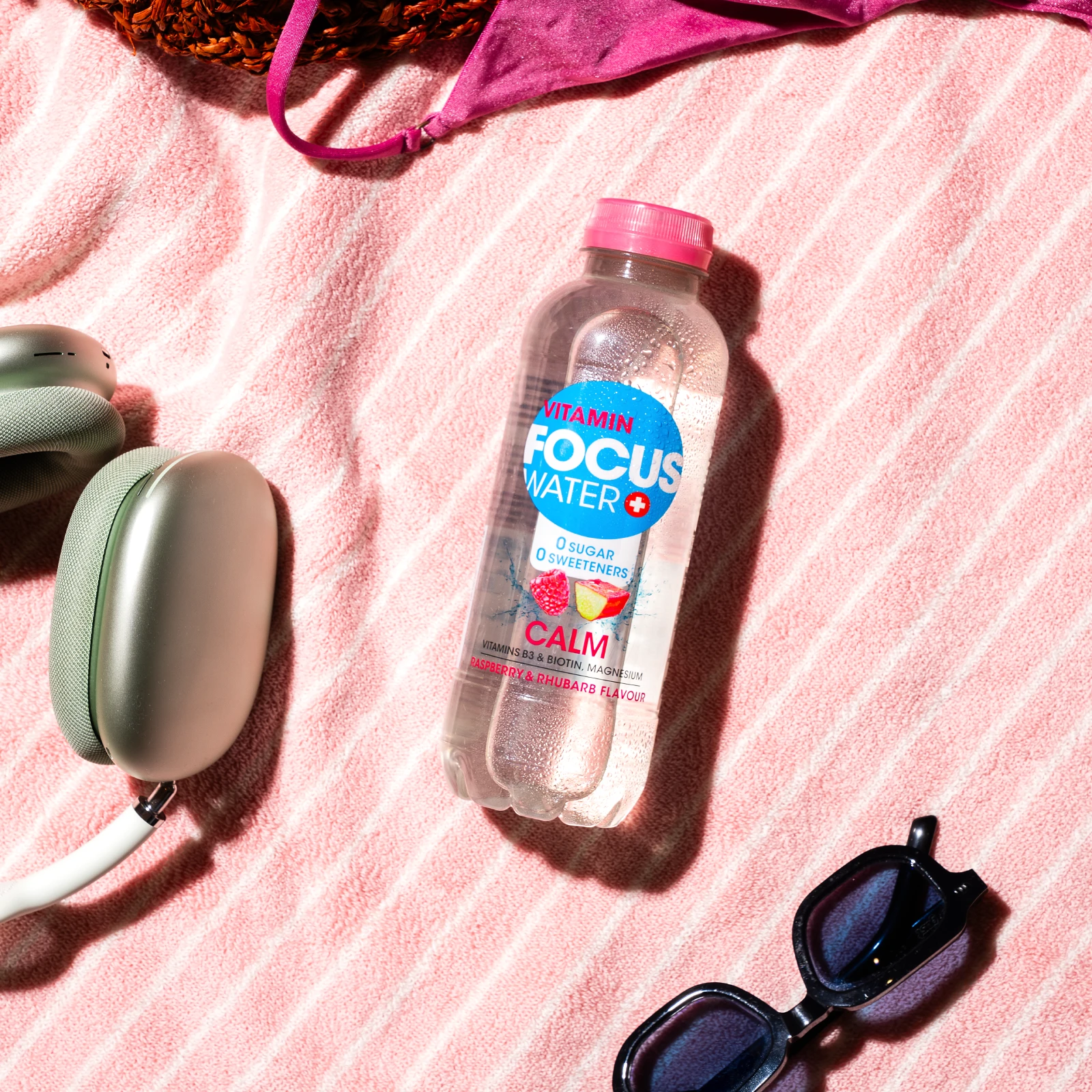 Focuswater Calm Flasche mit Himbeer-Rhabarbergeschmack auf rosa Handtuch.