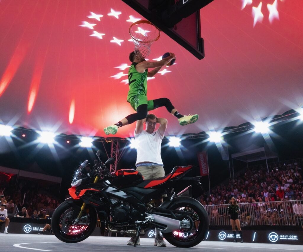 Basketballspieler im Sprung während eines Spiels in beleuchteter Arena.