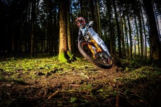 Mountainbiker Noel Niederberger im Wald, dynamische Szene mit spritzigem Fahrstil.
