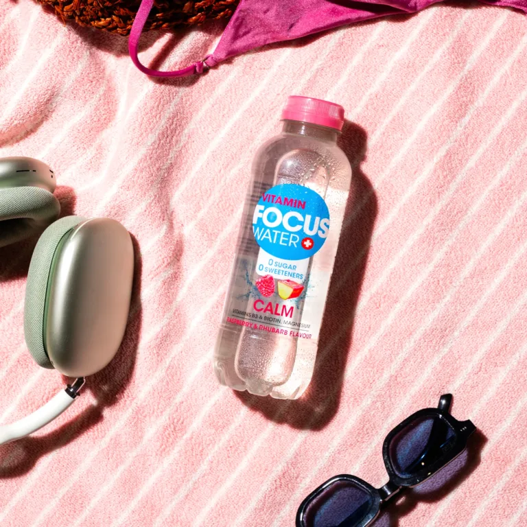 Focuswater Calm Flasche mit Himbeer-Rhabarbergeschmack auf rosa Handtuch.