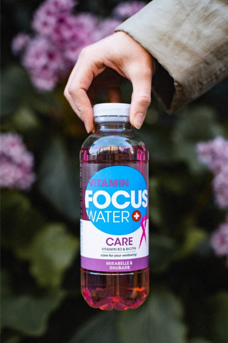 Eine weibliche Hand hält eine Focuswater Care Getränkeflasche in der Hand