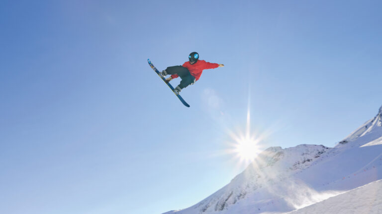 snowboarder fährt über eine schanze und spring in die höhe