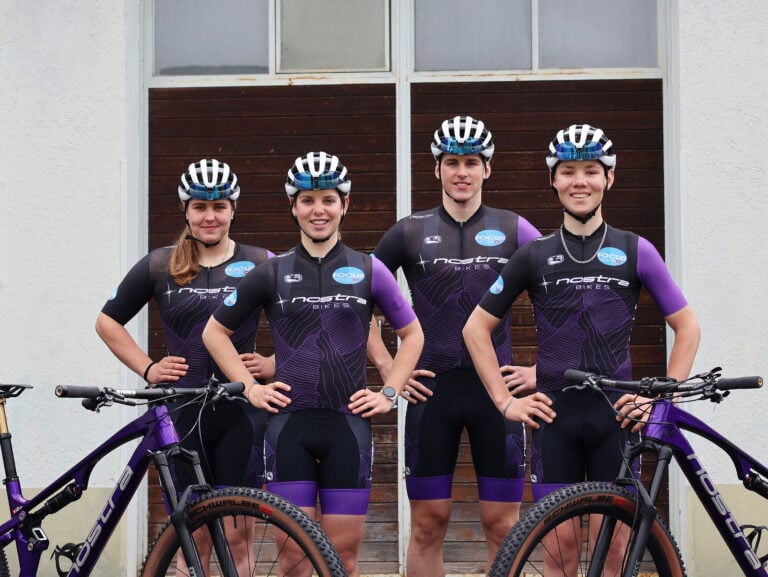 Vier Radsportler in Focuswater-Trikots posieren mit Fahrrädern.