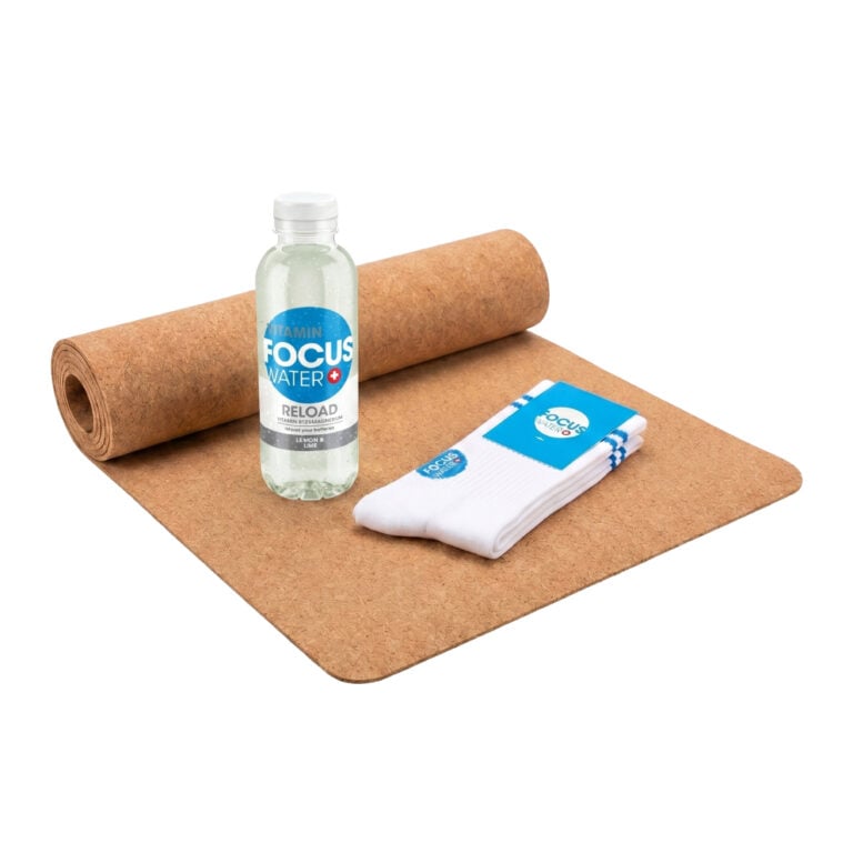 Focuswater Reload Flasche mit Yogamatte und weißen Sportsocken.